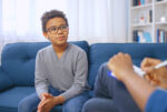 Student with glasses sitting on couch